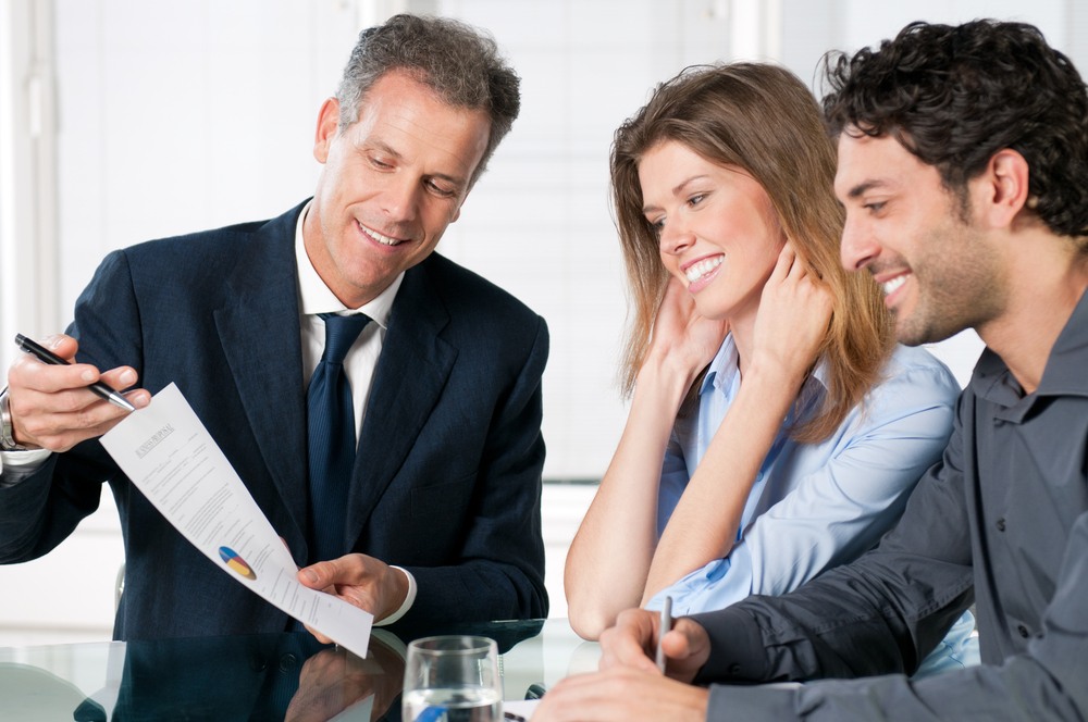Happy,Young,Couple,Discussing,With,A,Financial,Agent,Their,New